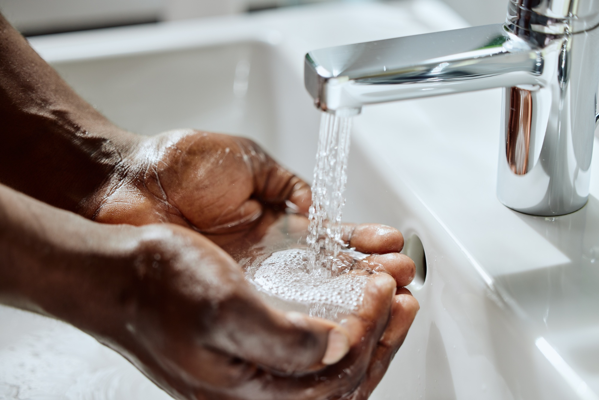 Black man, house bathroom or washing hands with water for healthcare wellness, hygiene maintenance