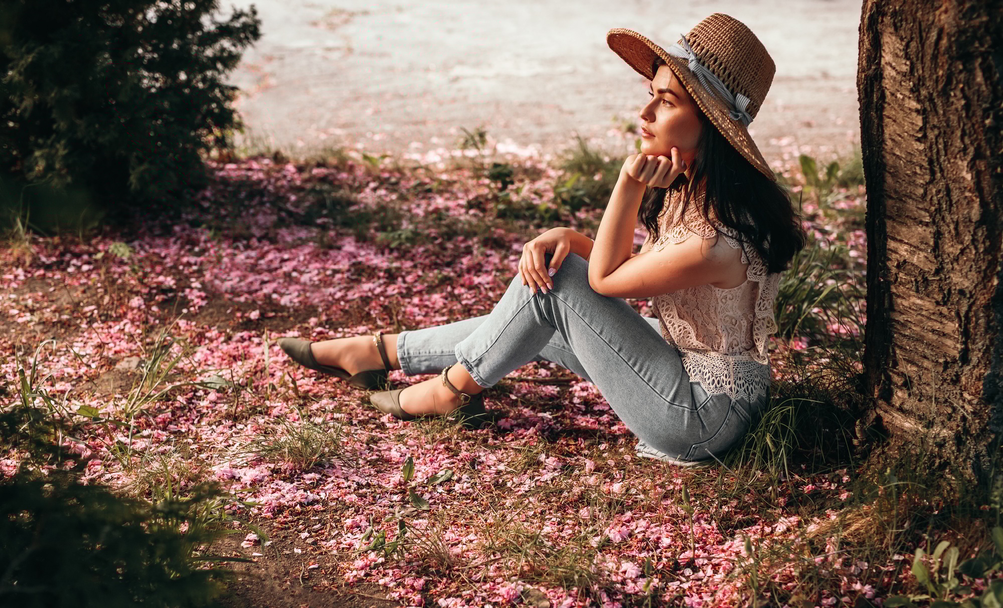 Young woman dreaming under tree in garden